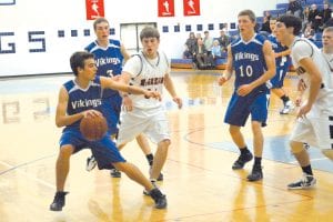 David Bergstrom gets ready to feed the ball to Dylan Quaife (10) while Ryan Martinson (3) looks over the shoulder of the McGregor player guarding Bergstrom. Despite playing an excellent game, the Vikings lost in the last seconds to the Mercs, who are top seeded team in the conference.