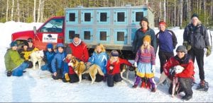 Ready to enjoy a day with the dogs! Enjoying the skijoring trip sponsored by MoeTown Kennels and Stone Harbor Wilderness Supply are (L-R) Karl Bottorff, Seth Kemp, Sherri Moe, Klaus Bottorff, Will Ramberg, David Blackburn, Finn Garry, Jack Stone, Lucy Callender, Linnea Henrikson, Peter Henrikson, Robin Henrikson, Mike Crook, Frank Moe with dog, Olwe Bottorff.