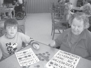 Sam Sietsema watches his own bingo card while helping Janet Morgan.