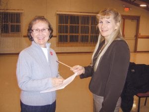 Outgoing Schroeder Township Treasurer Mary VanDoren (right) passes the “baton” over to Alicia Kangas after the annual elections and town meeting Tuesday, March 8, 2011. She was relieved to have a break after 11 years in the position. In recognition of all her dedication and service, she was named Citizen of the Year.