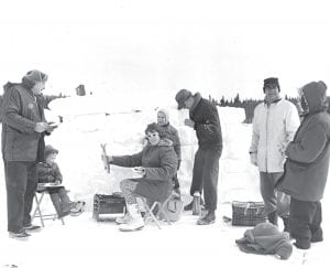 Another photo of a Grand Marais Lions Club Trout Derby circa 1965. There wasn’t just ice fishing; there was snow fort making, and dinners on the ice. Does anyone know this family group? Is the woman holding a prize-winning fish?