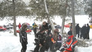 Lower left: Snowmobilers stop for a snack and socializing on Echo Lake.