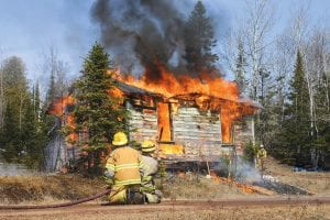 Firefighters from the Lutsen, Tofte, Schroeder, and Colvill fire departments conducted live-burn exercises in Lutsen on Saturday, April 9. Firefighters practiced the skills they learned in Firefighter I and II training, burning three structures. Firefighters Nate Clay and Matt Farley stand ready on fire hoses to ensure the fire does not spread from the burning cabin.