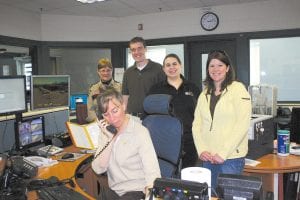 The emergency telecommunications professionals—dispatchers—who answer 9-1-1 calls and oversee the jail in Cook County are (L-R) Dispatch Supervisor/Jail Administrator Judy Sivertson, Nanette Arands (front, on phone), Kevin DeRosier, Darcy Ziller, and Lindsay Mielke. (Not pictured, Doug Gale)