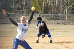 Left: Sarissa Falk went into her wind-up against Carlton last Thursday afternoon while Kristina Rude backed her up at shortstop. Above: Brea Boomer, stocking cap and jacket firmly on, throws the ball back into the infield. The Vikings lost 13-0 to the Bulldogs on a cold, cold day to play softball.