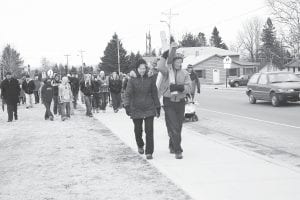 Dark clouds threatened rain, but the bad weather held off for the Annual Community Crosswalk on Friday, April 22. The crosswalk procession began at St. John’s Catholic Church and headed west along West Fifth Street before heading down the hill to Highway 61 and back up again. Members of different churches took turns carrying the cross. Here, Paul Muus shoulders the cross, accompanied by his wife, Bonnie.