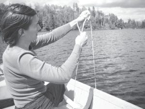 SWCD Program Assistant Theresa Oberg checking water clarity on Leo Lake.