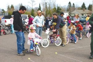 Little Alexis Plummer is at the head of the long line of bikes at the Thursday, May 12 Bike Rodeo. She was accompanied on the safety course by her dad, David Plummer. It was a beautiful day for little bike riders and their parents.