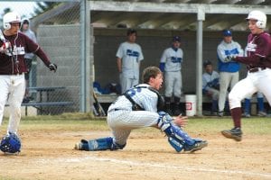 Above: Ben Kroska blocked the plate, caught the ball and despite a violent collision, put the tag on the Two Harbors runner for an out.