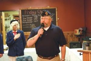 Naval Chief Petty Officer Ted Flack (Retired) sang the National Anthem. Behind him, hand on heart, is Eloise Christianson.