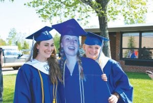 Adding a bit of merriment to graduation, Class President Amber Todd (left) and Valedictorian Ailee Larson strike a pose with a cardboard cutout of their friend and Salutatorian Molly Rider, who couldn’t be at graduation on Saturday, June 4, but sent a life-sized substitute to share the memories. See more of the 2011 commencement exercises on page A3.