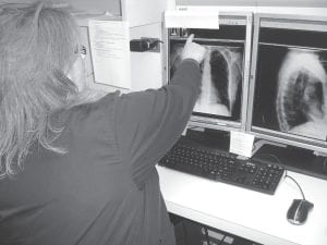 X-ray CT Tech Kathy Fladung shows the hospital board the wonders of the new CT computer program that can take multiple overlapping x-ray images and create three-dimensional views out of them. The images can be zipped off to radiology specialists around the country for readings in as few as five minutes any time of the day or night.