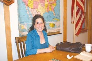 Author Danielle Sosin signs books at the teacher’s desk on display at the Cross River Heritage Center in Schroeder June 3. She is touring Lake Superior upon publication of her novel, Long-Shining Waters, which depicts characters living on Lake Superior in three different eras.