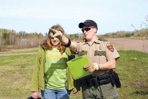 Above: DNR Conservation Officer Mary Manning explains the ATV driving course to MaeAnna LaFavor. Left: Volunteer instructor Chuck Silence gives a review of operating equipment on the ATV to MaeAnna LaFavor before she completes her field test.