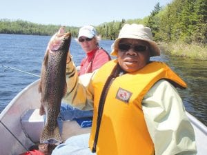 Syl Booth of Maplewood, MN shows off the beautiful rainbow she caught while fishing with Vince Ekroot of Little Vince’s Fishing Guide Service. With her is Shirley Bahneman, also of Maplewood. The women caught their limit of rainbows on the trip.