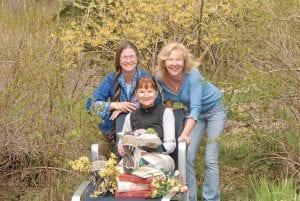 Posing with some of their favorite flowers and storybooks are three “characters” involved in planning the West End Garden Show, Posies ‘N Prose. (L-R) Gale Ring, Linda Walker (seated), and Lisa Hemp.