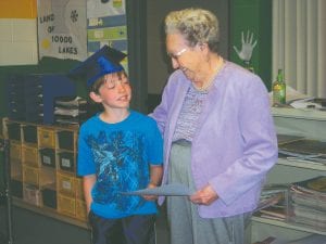 The Birch Grove Community School PTO recently recognized Iola Wojtysiak for her hard work. Iola made and sold hundreds of colorful potholders, raising $2,000 for the Birch Grove Community School hot breakfast program. Presenting the certificate of appreciation is Iola’s greatgrandson Masen McKeever. Potholders will also be available for purchase at the Tofte 4th of July celebration.