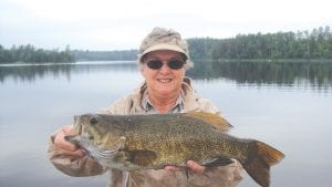 Holly Clark from Indiana, with the nice 20.25-inch smallmouth bass she caught and released on the Canadian side of Lake Saganaga on Sunday, June 26. According to Marco Manzo III of Sagonto Resort on Sag, Holly and her husband Kirk come to Lake Saganaga only for the bass/northern fishing—the walleyes are thrown back!