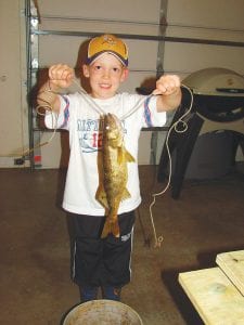 The kids enjoyed learning the fun of fishing with Grandpa Dick Dorr and Dad Mitch Dorr of Grand Marais. Above, Jacob Dorr with his first walleye.