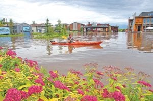 The thunderstorm in the early hours of the morning of July 20 dumped 3.75 inches of rain on the city of Grand Marais and many other areas of Cook County. The municipal lot was flooded as it usually is after a big rain. Ben Peters of Stone Harbor Wilderness Supply enjoyed a kayak ride. He and other Stone Harbor staffers used kayaks and stand-up paddleboards to help customers reach flooded businesses. More storm photos on page A3.