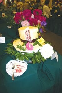 The 77th annual Grand Marais Garden Club show Friday, July 15, 2011 at the Cook County Community Center was another success. Club members celebrated the theme of “Hats off to Flowers” by donning vintage hats. Many of the entries very creatively integrated hats into their arrangements. Rebecca Thompson even made a hat-shaped cake (top, center) , which she decorated with flowers. The beautiful young woman in front of the wall of hats is Grace Blomberg of Grand Marais.