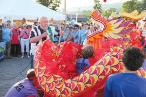 Left: Mayor Larry “Bear” Carlson had the honor of “waking the dragon” to start the 2011 festival. Carlson shared a quote from St. Urho, noting that if the Finnish saint could scare the grasshoppers out of Finland, he could certainly wake a dragon. Well done, Mayor Carlson! Above: The Women on the Edge fielded two teams in the Dragon Boat Festival—and they looked ravishing in evening dresses in Friday’s Parade of Teams.