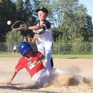 Josh Prom of the Dodgers waits for the throw as Colton Furlong of the Twins slides underneath the tag. The Twins won the Little League Championship Game 8-4.