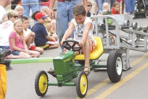 Kids from ages 4 to 11 enjoy the Lions Club tractor pull. Left: Haylee Hanna, of Vadnais Heights, gave it her all when it was her turn to go. Above: C.J. Luehring of Grand Marais gave a great pull too.