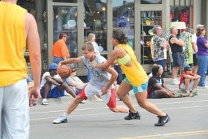 Hoopin’ in the Harbor, sponsored by the Cook County Viking girl’s basketball team filled the east end of Wisconsin Street with a lot of energy. Above: Grimacing, Colin Everson tries to drive around former Viking Christina Nelson. Even palming the ball didn’t help him though, as Nelson shut the door on Colin and he had to pass the ball. Left: Ryan Martinson goes up, up, up to get his shot off over Essa Jacobsen, scoring two points for his team. The winning team was the “A-Team” of Brea Boomer, Ashley Deschampe, Juice Washington, and Chavez Fez.