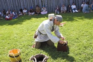 A fierce competition at Rendezvous Days is the Rugged Voyageur Contest. Thirteen voyageurs competed to see who could carry a pack, press beaver pelts, kiss the cook, drink some “high wine” and start a fire the fastest. This year’s winner was John Hayes of Cohasset, MN, shown here preparing to start a fire. His fire-starting skills gave him the edge over his competitors.