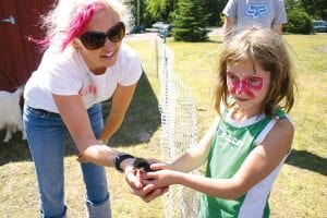 Heidi Doo-Kirk helps Olivia Nesgoda hold a little chick at the Cook County Fair on August 20, 2011. It was one of numerous small animals on hand at a petting zoo hosted by Doo-Kirk and Jinsey Smith. Youngsters enjoyed a lot of fun activities at the fair, including carnival games, face painting, an inflatable obstacle course, a bouncy house, and even getting showered by water from a fire truck. Adults found intrigue with all the fair entries and exhibitors inside the Community Center. See more fair fun on page A13.