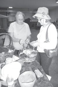 A fair exhibitor shows a fairgoer her wool, dyed in many vibrant colors.