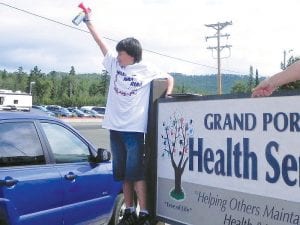 Last week the Cook County News-Herald shared photos and results of the 2011 Grand Portage Rendezvous Day Run - Walk. The people who participated in the Run – Walk received a T-shirt with an energetic design declaring “Walk! And! Run!” The T-shirt designer was Marcus Logan of Grand Portage, pictured here sounding the horn to start the Rendezvous Days event.