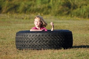 Is she adrift at sea or is she prowling the jungles looking for a lion? We’ll never know for sure, but while her big sister took part in soccer practice, Emma Gesch found a new use for the tires used by the football team for drills.