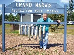 A longtime visitor to Grand Marais, Shell Angle, with his catch of trout and salmon. Angle had a great day of fishing aboard the Secret Lure with Captain Jerry Skarupa on August 25.