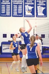 Sarah Fagerman went up high to slam this ball while Ashley Deschampe (5) and Abby Sutton (7) looked on.