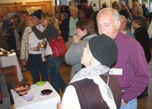 Above: Artists and printmakers Betsy Bowen and Jerry Riach discuss some of the work on display. Right: Kristen Blomberg’s daughter, Grace, proudly tells Buddy Skinner about her mother’s artwork, two lovely pastels entitled Birch Shed and Last Rays.