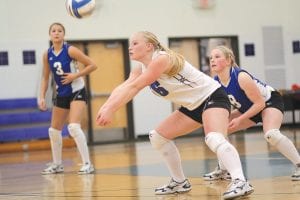 Positioning in volleyball is everything. While Theresa Morrin (3) looks on, Cecelia Olsen gets ready to bump the ball to a front line teammate. Anna Carmen (8) is backing up Cecelia on this play. Very few serves fall for aces against the Vikings because the girls know where they should be on the court at all times.