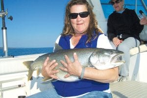 September 25 was a great day to be fishing on Lake Superior. Left: Lynn Hollenback, from Bloomington MN, caught this huge 23-pound, 40-inch lake trout. Below: Peggy Mullin, from Bloomington MN, caught this very nice 20-pound, 36-inch lake trout. Helping her hold the big fish is her daughter, Mia Hollenback. Both fish were released. The women were fishing with Captain Darren Peck of Tofte Charters.