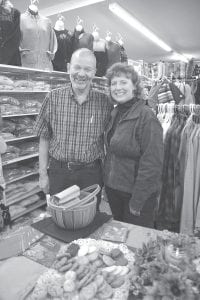 Above: Kindly shoe salesman Bill Wissman will leave an empty spot at Joynes Ben Franklin in Grand Marais when he moves to Chicago to live with his daughter and her family. He has been a fixture at Joynes for 25 years and many will fondly remember his gentle demeanor and friendly smile. He is excited about spending time with his three-year-old granddaughter. Many well-wishers attended his going away party on October 11. He is pictured here with Julie (Joynes) Carlson. Left: Two giant boots with flowers and balloons greeted customers at Joynes Ben Franklin in Grand Marais on October 11, marking the party for Bill. The thank-you balloons expressed some of the fondness the community has for him.