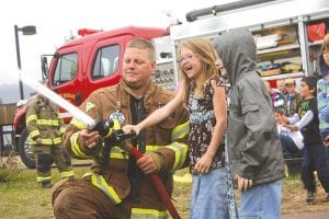 The Colvill and Grand Marais Fire Departments visited Sawtooth Elementary. Colvill Firefighter Shane Danielson lets Bryn Allen have a turn on the fire hose, much to her delight.