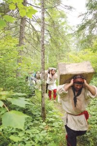 Left: The scenery in Rendezvous with History: A Grand Portage Story was absolutely beautiful and encompassed all four seasons. This photo shows voyageurs making their way along the grueling Grand Portage during the July 2010 movie shoot.