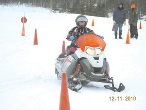 A student maneuvers around traffic cones to demonstrate what she learned about operating a snowmobile in the 2010 snowmobile safety course.