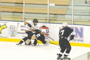 Above: Even falling down, Quaid Cavallin had the presence of mind to find Will Hartman with the puck. Left: Will Hartman deftly wields the puck through the Denfeld defenders as Nathan Bauck (19) gets ready to receive a pass.