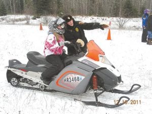 Conservation Officer Mary Manning explains the course to a snowmobile safety student. In addition to driving, students learn about a variety of topics such as winter survival, snowmobile regulations, courtesy and ethics.