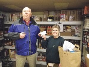 Tom Hedstrom of Grand Marais happily presented a check from Emera Chapter 160, Order of the Eastern Star, to Gwen Lenz of the Cook County Food Shelf.