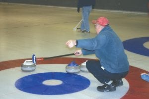 Bob Sopoci calls for his sweepers to let the rock curl a little bit more before they sweep it into the house. Sopoci is helping to teach about a dozen men from ages 65 to 85 to curl. The group gets together on Wednesday afternoons and after three practices most already have a good feel for the game. Because they mostly live in the West End, the fellows appreciate curling in the daylight to avoid driving home in the dark.