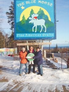 The “people’s choice” winner of the 2011 business holiday lighting contest was the Blue Moose on the west end of Grand Marais. Accepting the $50 prize (left) is Laurie Kriz, and she is standing next to Rene Swadburg, holding the winner’s badge. On the right is Maggie Barnard, events manager for the Cook County Visitors Bureau, which sponsored the contest along with the Grand Marais Chamber of Commerce. Kriz and Swadberg, who work for Blue Moose owner Bill Doucette, spent three days planning their lighting display. It incorporated a lot of white, blue, and green lights with red accents on the gazebo in front of the business.