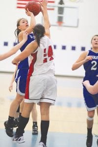 Despite tight defense, Ashley Deschampe (left) shoots and scores against an Ely defender last Saturday afternoon in their double-overtime win against the Timberwolves. Jessica Berg- Collman (middle) juked out her defender and scored on this lay-up and Breana Pederson (above right) drove the baseline and hit Bekah Laky with a nice pass, which Laky converted for two points in the win against Ely.