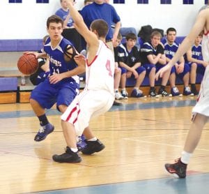 David Bergstrom (above) looks to drive around the Ely defender last Friday night. Jonny Jacobsen (right) puts up a shot against the outstretched arm of an Ely defender and Kale Boomer (far right), who had a couple of baskets taken away from him on charging calls, stayed positive and took the ball to the basket on drive and drive against Ely.